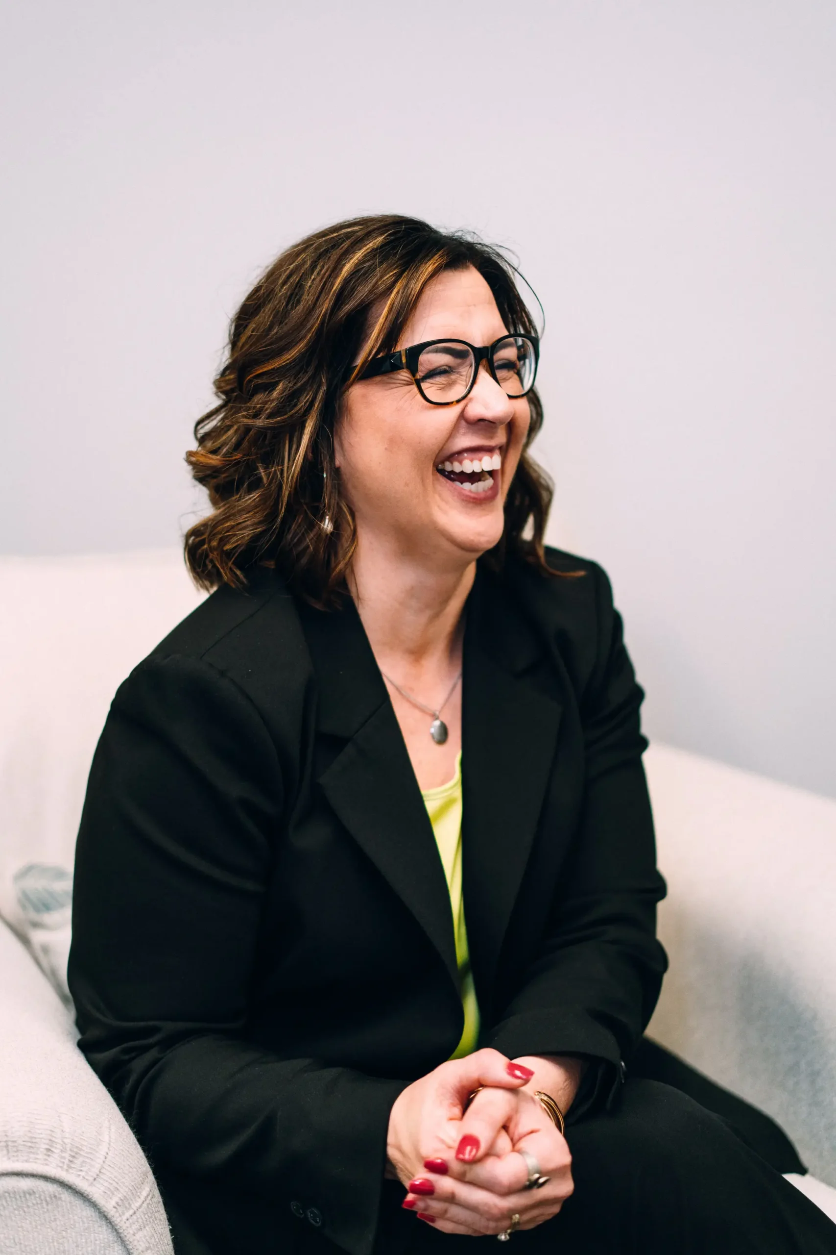 A Supporting Wellness therapist laughing in a bright counselling room
